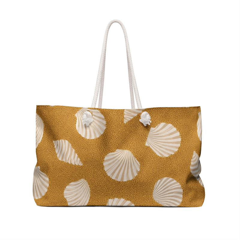 Shell Pattern Weekender Bag — angled side view showing the rope handles and grommet hardware, scattered scallop shell print on golden sand