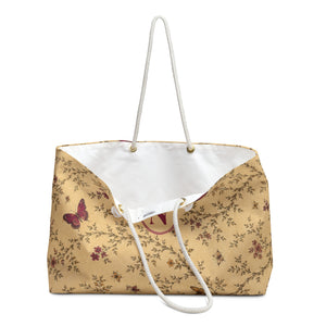 Close-up of the personalized "N" monogram medallion on the Monogram Butterfly Floral Weekender Bag