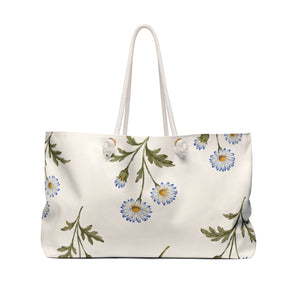 Monogram A Daisy Weekender Bag — angled side view showing the rope handles and grommet hardware, soft blue daisy print on cream canvas