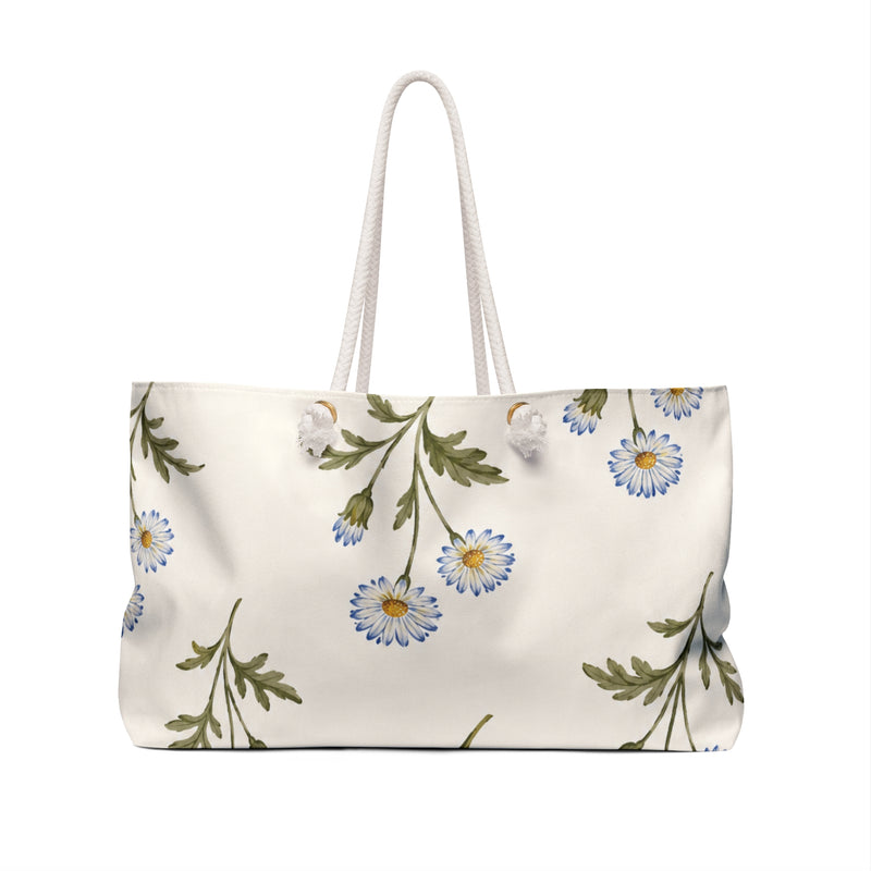 Monogram A Daisy Weekender Bag — angled side view showing the rope handles and grommet hardware, soft blue daisy print on cream canvas