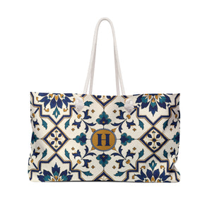 Monogram "H" Tile-Print Weekender Bag – front view showing the navy, teal, and gold tile-inspired print