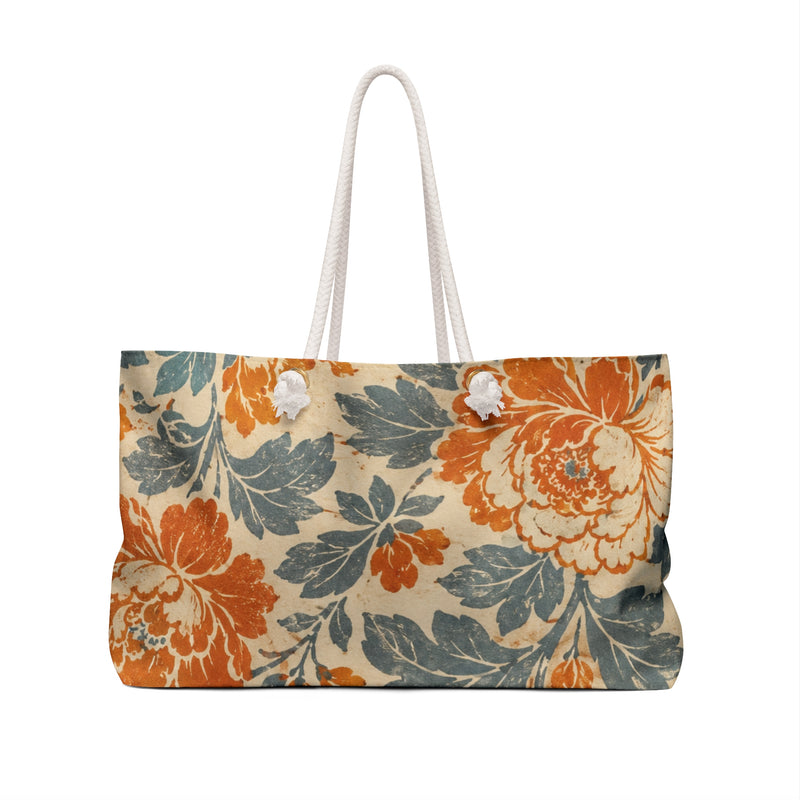 Floral Weekender Bag Vintage Orange Teal — angled side view showing the rope handles and grommet hardware, rust-orange and teal vintage floral print