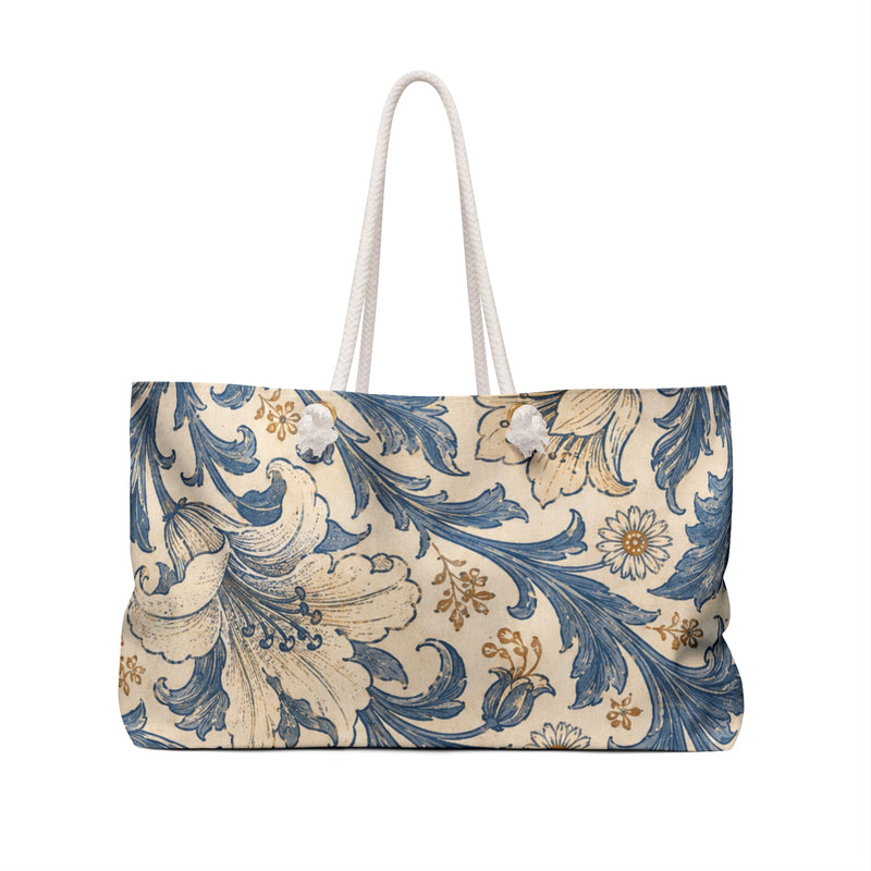 Floral Vintage Blue Weekender Bag — angled side view showing the rope handles and grommet hardware, painterly indigo-blue and cream floral print