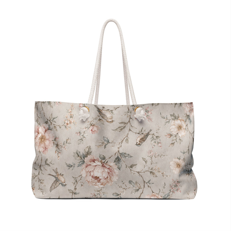 Floral Bird Weekender Bag — angled view showing thick cream rope handles and gold-tone grommets