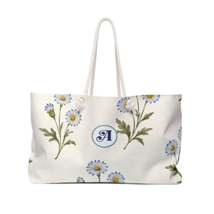 Monogram A Daisy Weekender Bag — front view showing the full exterior print, soft blue daisy print on cream canvas