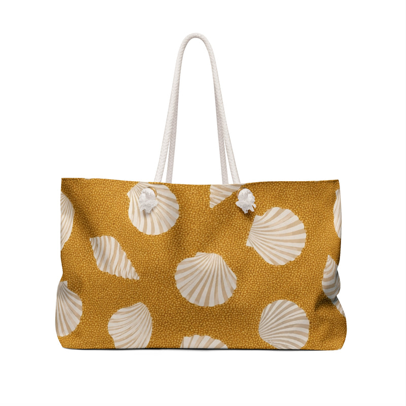 Seashell Sand Weekender Bag — angled side view showing the rope handles and grommet hardware, cream shell motifs on golden-sand canvas